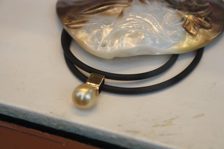 A pearl on a necklace on display